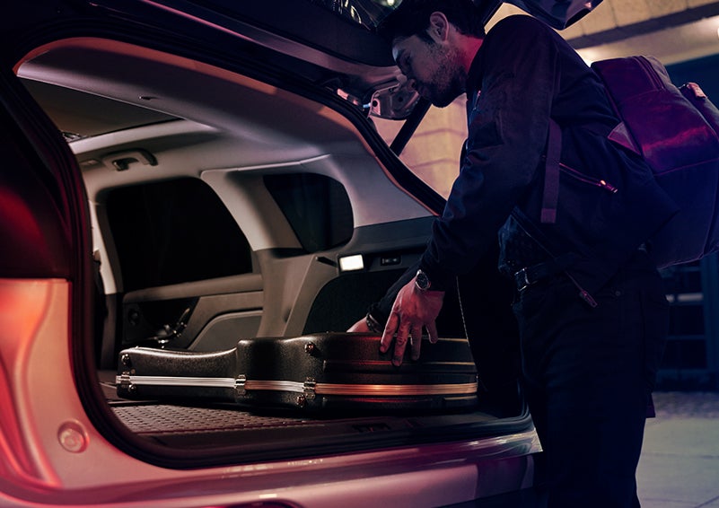 A man is shown loading cargo into the rear of a 2024 Lincoln Corsair® SUV with the second-row seats folded flat. | Purchase Lincoln in Mayfield KY